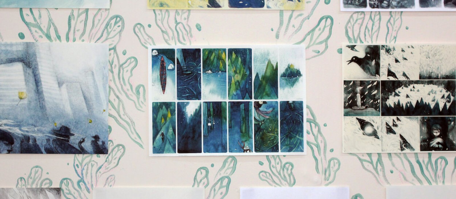 Display of illustrations of woodland, birds, figures, kayak and mountains.